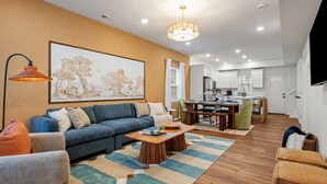 A modern living room with a sofa, coffee table, and artwork on the wall.