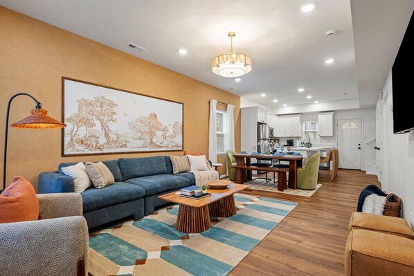 A modern living room with a sofa, coffee table, and artwork on the wall.