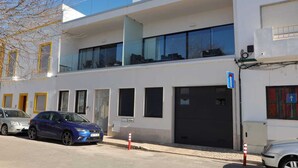Un edifici modern amb una estructura de dos pisos, grans finestres i una porta de garatge.