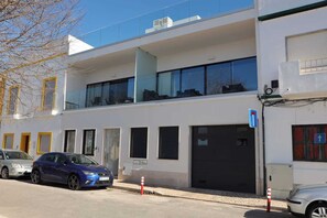 A modern building with a two-story structure, large windows, and a garage door. - JB Ria Mar ll by Meditrust (Alvor)