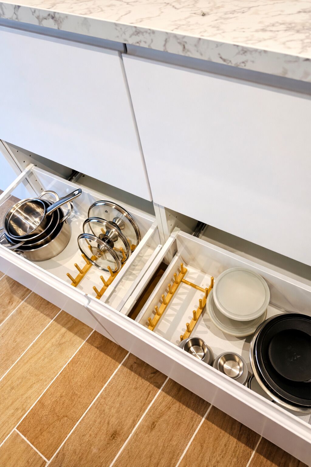 Un tiroir de cuisine contenant des ustensiles de cuisine, des casseroles, des poêles et d’autres accessoires.