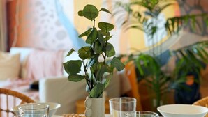 Une table à manger avec de la belle verrerie, un vase décoratif et un tableau en arrière-plan.