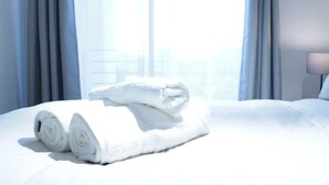 A neatly made bed with rolled white towels, a lamp, and curtains in a hotel room. - Disegni 19 - Dpto. Downtown Copiapó City View (Copiapó)