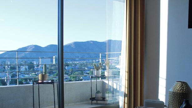 A balcony with potted plants, a cityscape view, and mountains in the distance. - Disegni 19 - Dpto. Downtown Copiapó City View (Copiapó)