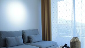 A modern living room with a sofa, a vase, and a window with a view of a cityscape. - Disegni 19 - Dpto. Downtown Copiapó City View (Copiapó)