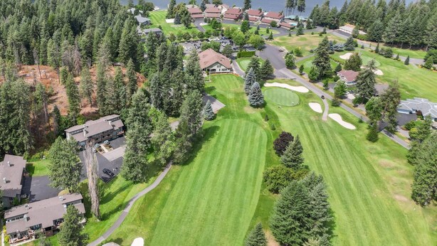 Vue aérienne d’un quartier résidentiel avec des maisons, un terrain de golf et un lac.