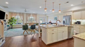 A modern kitchen with a central island, stainless steel appliances, and pendant lighting.
