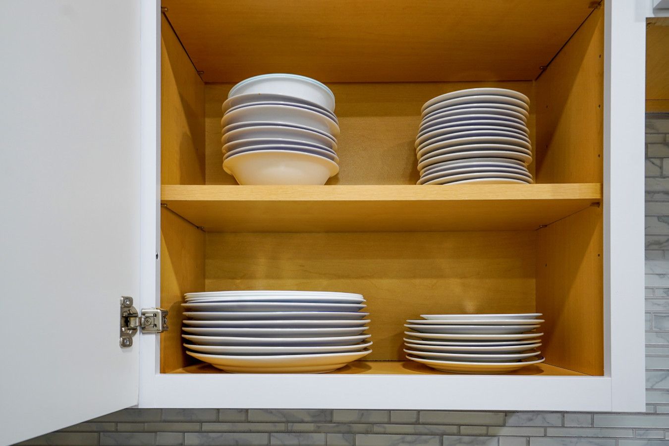 A cabinet with multiple shelves holding stacked plates.