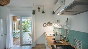 A kitchen with a wooden countertop, a coffee-themed wall decoration, and hanging plants.