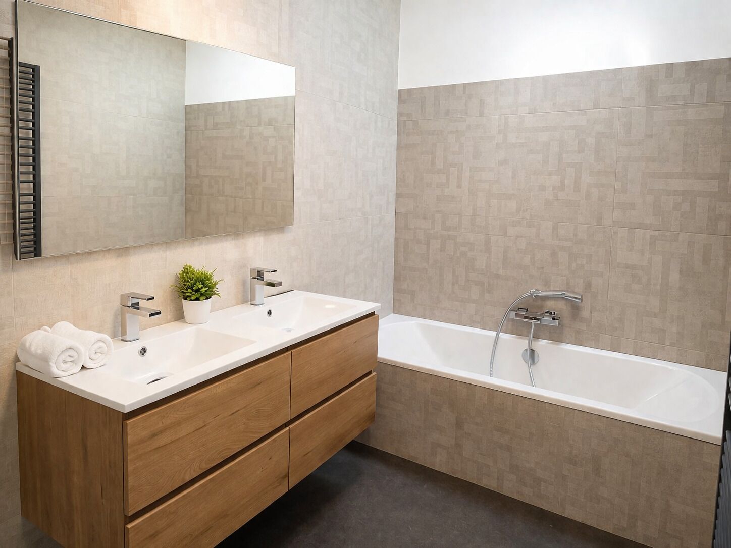 A modern bathroom with two sinks, a large bathtub, wooden cabinetry, and a mirror.