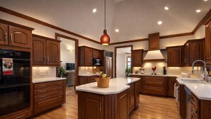 Une cuisine moderne avec des meubles en bois, un îlot central et des appareils électroménagers intégrés.
