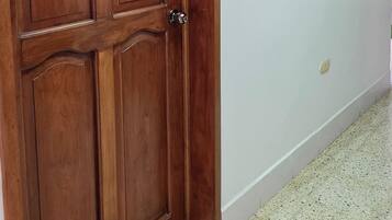 A hallway with a wooden door and a window with frosted glass.