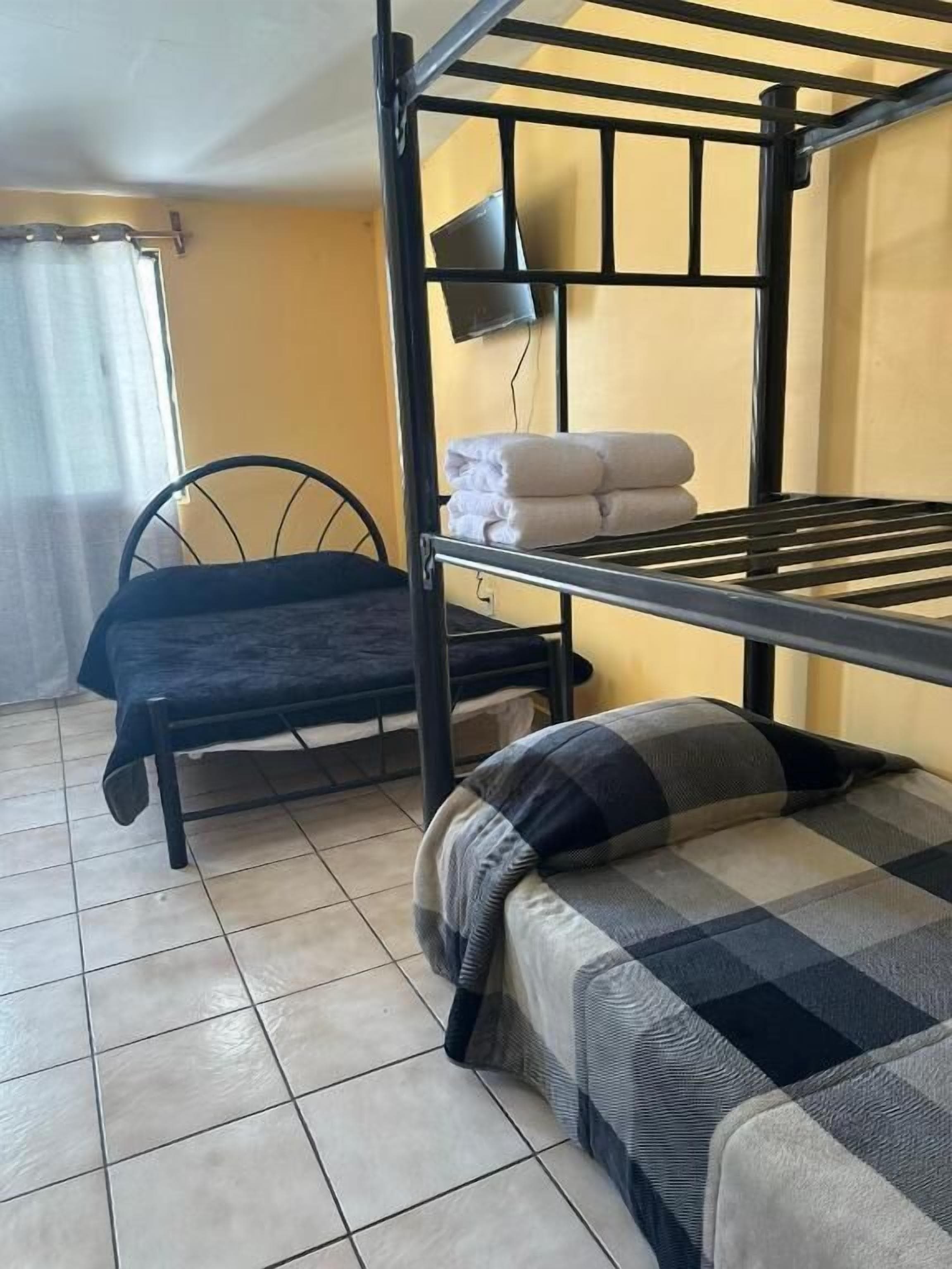 A bunk bed room with a single bed, a chair, and a small table.