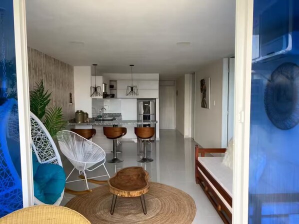 A modern kitchen with white cabinets, a central island, and bar stools. - CARTAGENA-Vista al Laguito 🌅 | Remodeled | VRBO Ready | Steps from the beach. (Cartagena de Indias)
