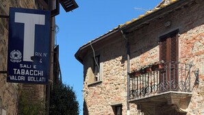 A narrow street with stone buildings, a bench, and a sign indicating a tobacconist.