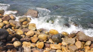 Un rivage rocheux où les vagues s’écrasent contre les rochers.