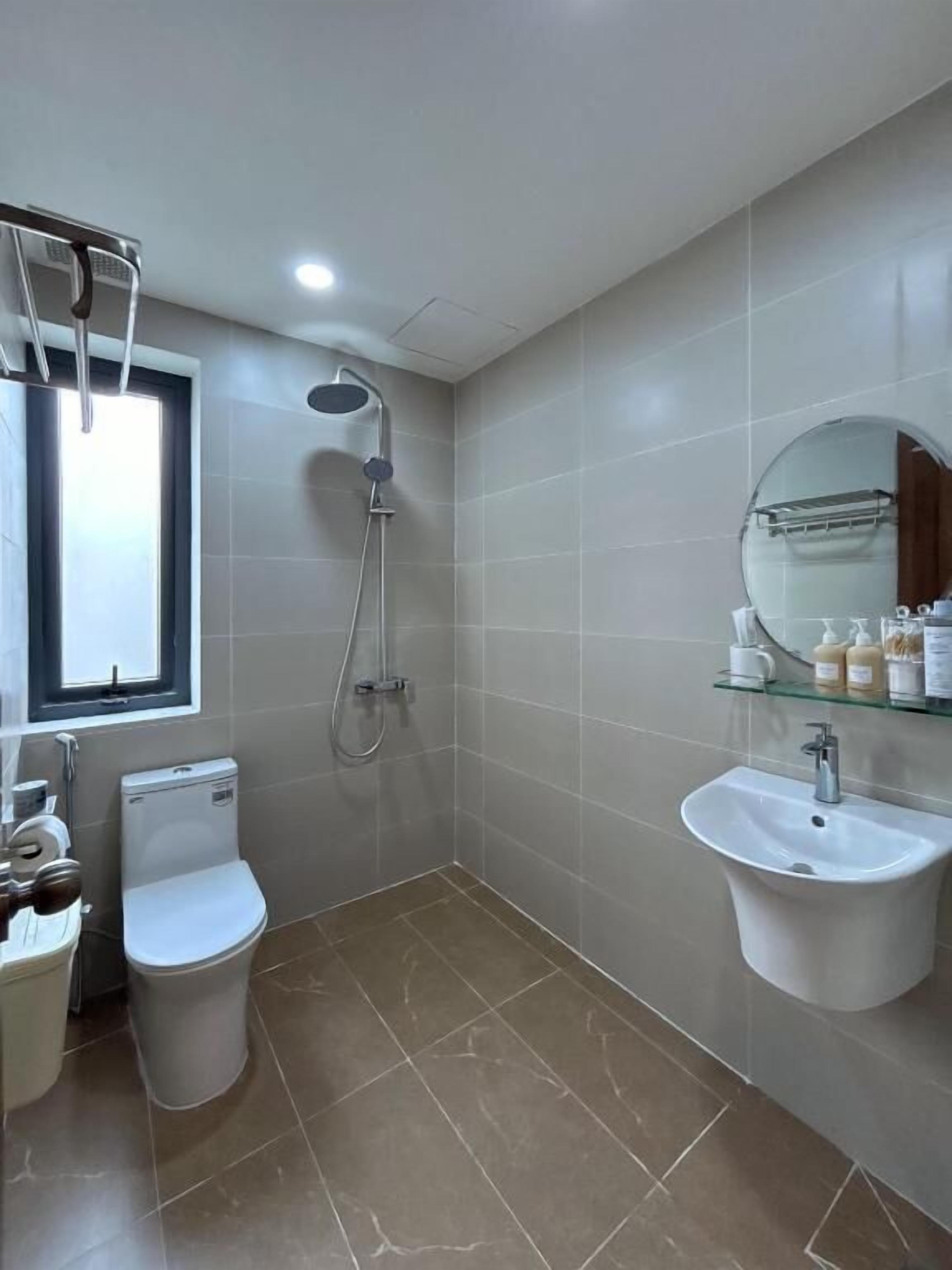 Ein Badezimmer mit Toilette, Bidet, Dusche und Waschbecken mit Spiegel darüber.