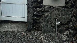 A stone wall with a metal box labeled 'Chave key' and a white gate. - Retiro dos Cabritos (Madalena)
