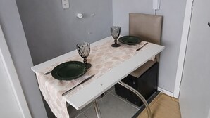 Een klein eethoekje met een tafel, stoelen en een stopcontact.