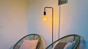 Two wicker chairs with cushions, a floor lamp, and a framed collage on the wall. - Casale Milleluci - double apartment in the countryside 10 min from the sea (SENIGALLIA)