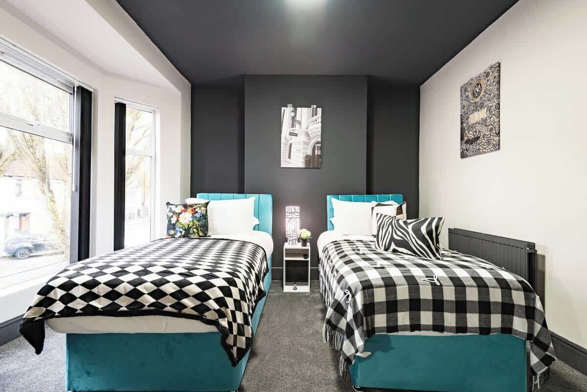 Een kamer met twee bedden, een kleine tafel en een raam.