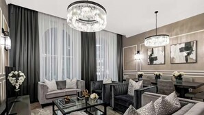 Ein modernes Wohnzimmer mit einer Couch, Sesseln, einem Couchtisch und einer Chandelier.