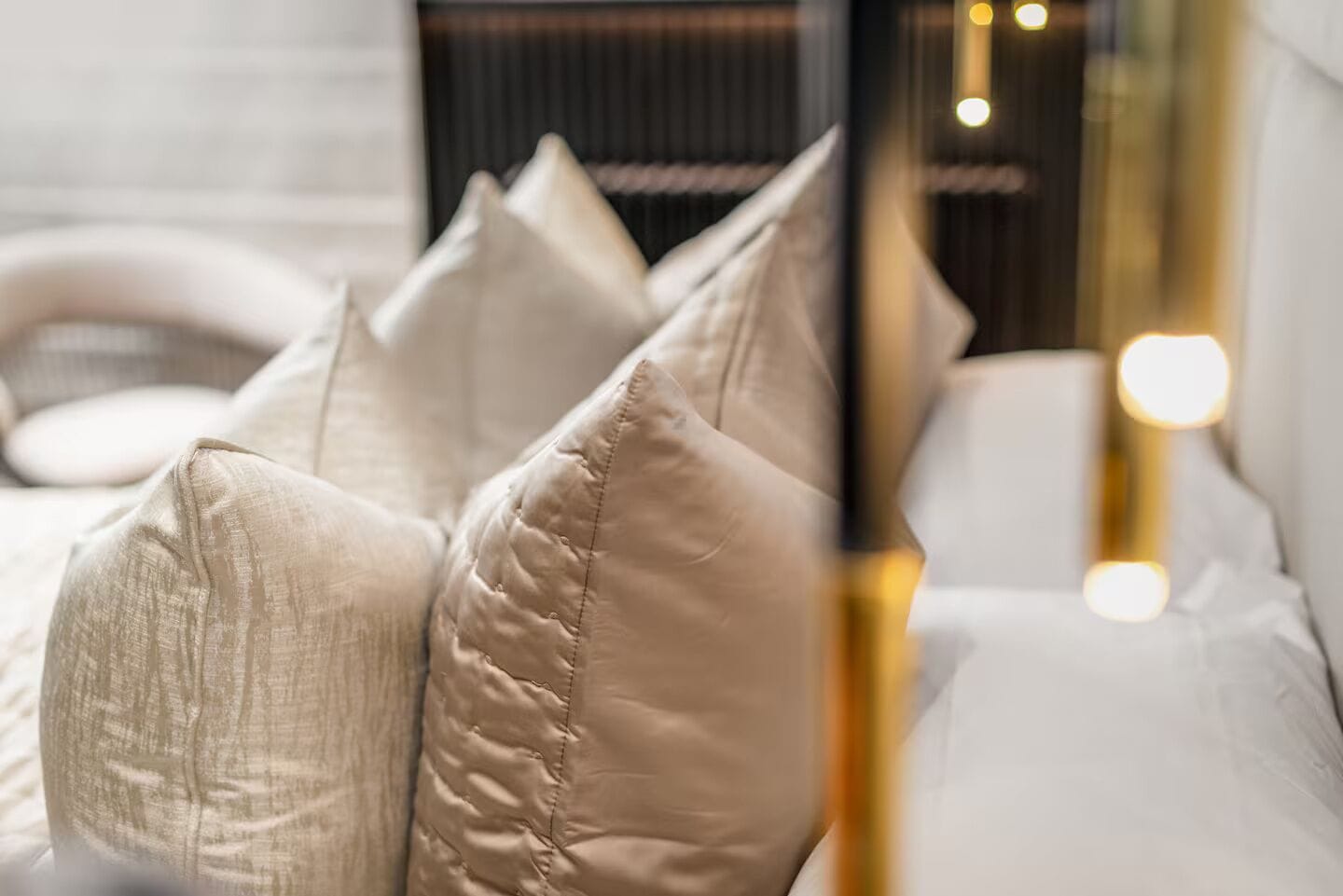 Ein Bett mit vielen Kissen und einer Nachttischlampe.