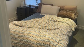 Una camera da letto con un letto, una lampada, una mappa appesa al muro e una finestra.