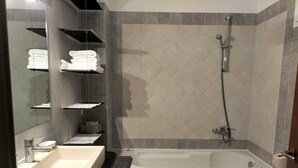 Ein modernes Badezimmer mit einer freistehenden Badewanne, einem Waschtisch und einer Toilette.