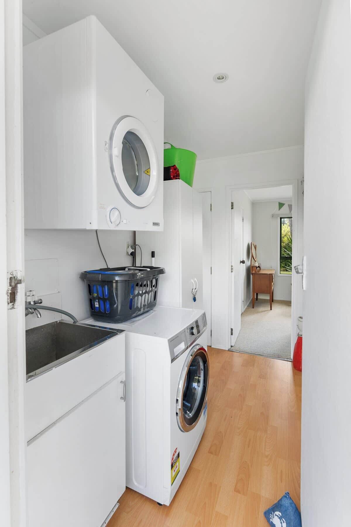 A laundry room with a washing machine, a dryer, and a sink.