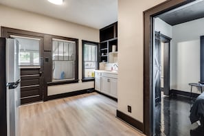 A compact kitchen with a refrigerator, cabinets, and a sink.