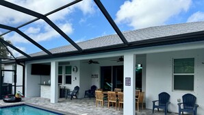 Un área de piscina interior con un patio cubierto, asientos y un cartel con las normas de la piscina.