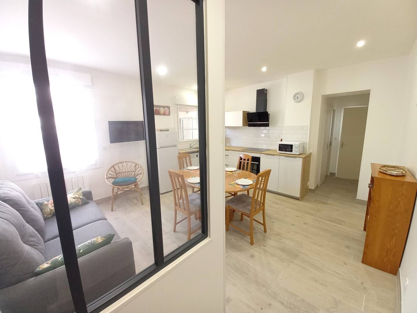 A modern apartment with a dining area, kitchen, and living room.