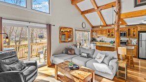 A spacious living area with a large sofa, a coffee table, and a wooden ceiling structure. - Slopeside Lodge at Sugar Mountain - Ski In/Out, Views, Near Water, Gas Fireplace (Sugar Mountain)