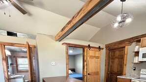 A kitchen with a wooden table, cabinets, and a ceiling fan.