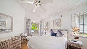 A bedroom with a large bed, a nightstand, a dresser, and a window with curtains. - Beachfront Villa with Plunge Pool - Waverly One (2 bed) (Gibbes Beach)