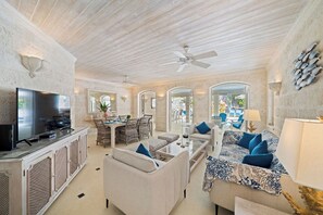 A spacious living area with a television, dining table, and comfortable seating. - Beachfront Villa with Plunge Pool - Waverly One (2 bed) (Gibbes Beach)