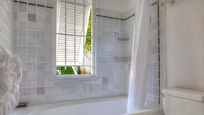 A bathroom with a bathtub, a window, and a toilet. - Beachfront Villa with Plunge Pool - Waverly One (2 bed) (Gibbes Beach)