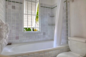 A bathroom with a bathtub, a window, and a toilet. - Beachfront Villa with Plunge Pool - Waverly One (2 bed) (Gibbes Beach)