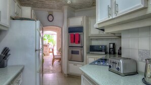 A kitchen with white cabinets, a refrigerator, an oven, a microwave, a toaster, and a coffee maker. - Beachfront Villa with Plunge Pool - Waverly One (2 bed) (Gibbes Beach)