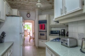 A kitchen with white cabinets, a refrigerator, an oven, a microwave, a toaster, and a coffee maker. - Beachfront Villa with Plunge Pool - Waverly One (2 bed) (Gibbes Beach)