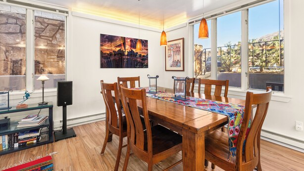 Un comedor con una mesa de madera, sillas y una estantería.