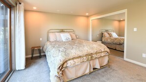 A bedroom with a bed, a small stool, a mirror, and a window with curtains. - SF Bay Area: Private Luxury “Treehouse” Retreat (Pleasant Hill)