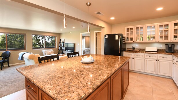 A spacious kitchen with granite countertops, wooden cabinets, and a large island. - SF Bay Area: Private Luxury “Treehouse” Retreat (Pleasant Hill)