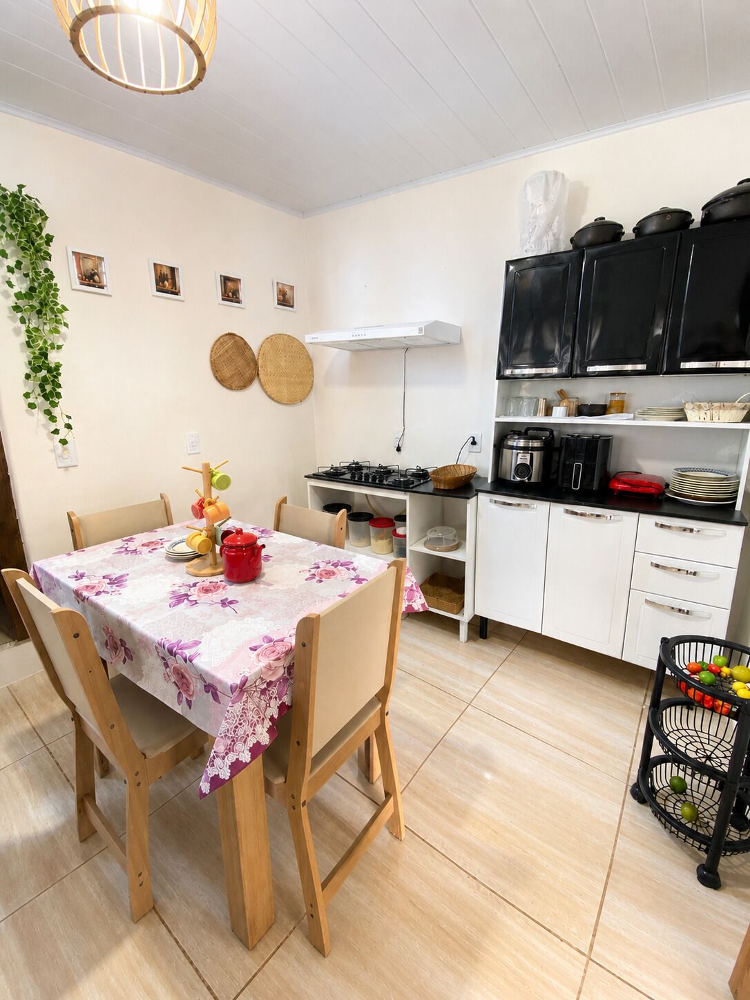 A compact kitchen with a dining table, chairs, and a variety of kitchen appliances and utensils.