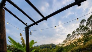 Une terrasse extérieure en bois offrant une vue sur une rivière et la verdure environnante.