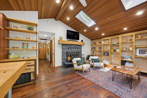Ein gemütliches Wohnzimmer mit Holzboden, Kamin und Einbauschränken.