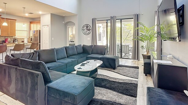 Ein großzügiger Wohnbereich mit Ecksofa, Couchtisch und Wand-Fernseher.
