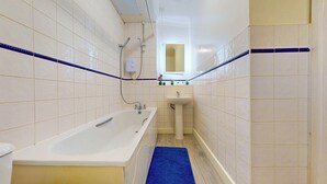 Un baño con bañera, lavabo y espejo.