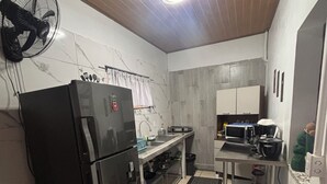 A kitchen with a refrigerator, microwave, and stove.